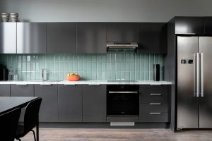 Cork Marsh's Yard. An image of a kitchen. Grey drawer units and cupboards with a stainless steel fridge on the right hand side. Turquoise backsplash