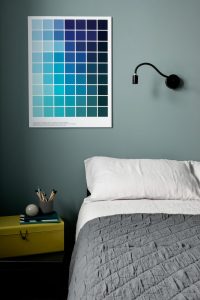 Cork Marsh's Yard. In the right foreground is a double bed. To the right is a bed side locker with a yellow tackle box on top. Above the box hanging on the wall is an aqua colour palette